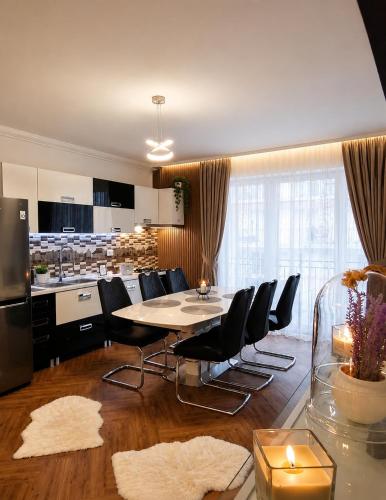 a kitchen and dining room with a table and chairs at Yoa Apartaments in Floreşti