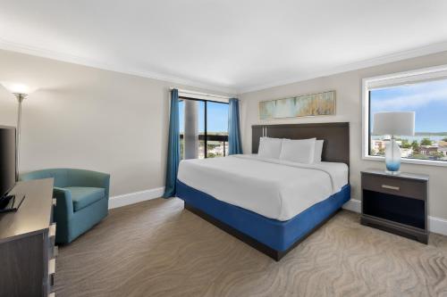 a hotel room with a bed and a blue chair at Bask Hotel at Big Rock Landing in Morehead City