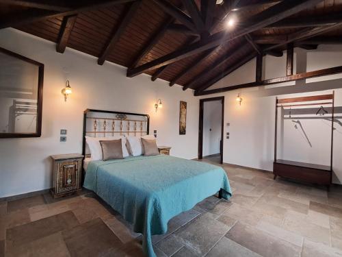 a bedroom with a bed with a blue bedspread at Nykteri Heritage House Olympus & Sea View in Palaios Panteleimonas