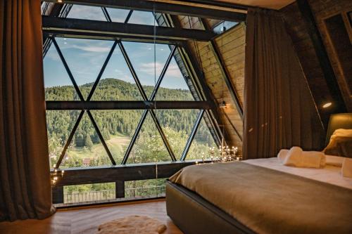 a bedroom with a large window with a view of a mountain at The Frame Croatia in Ravna Gora