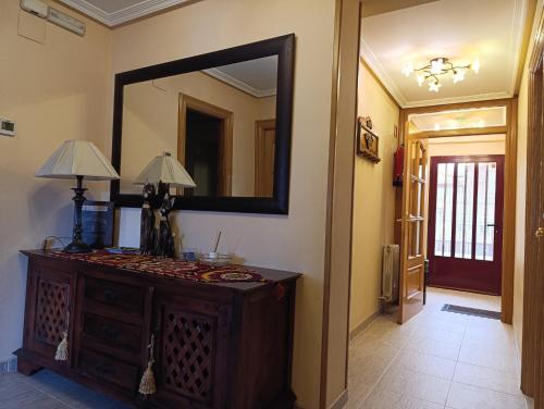 a mirror on a wall with a dresser in a hallway at Fuenteazul in Hortigüela