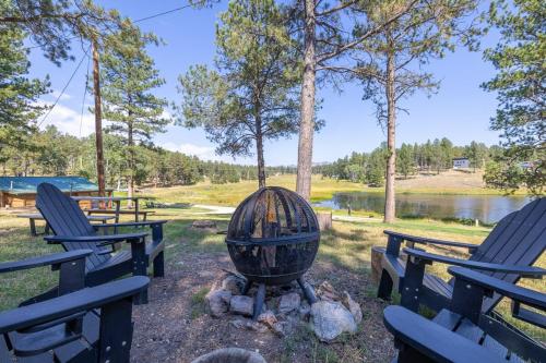 a fire pit with two picnic tables and chairs at Pondside Lodge BHBungalows #5 in Custer