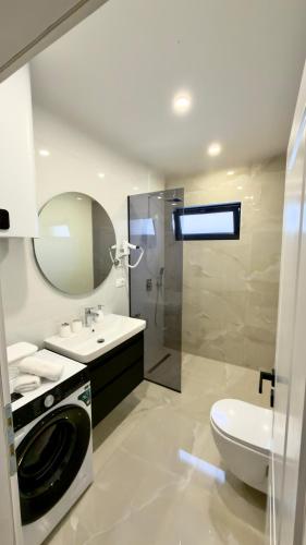 a bathroom with a sink and a washing machine at Villa Maja in Blagaj