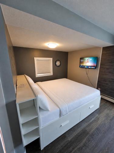 a bedroom with a large bed and a tv at 94 Motel & RV Park in One Hundred Mile House