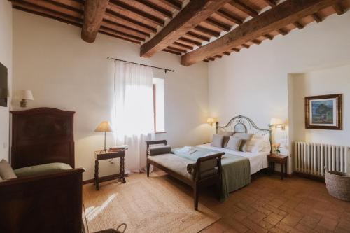 a bedroom with a bed and a chair in a room at Hotel Relais Santa Genoveffa in Paganico