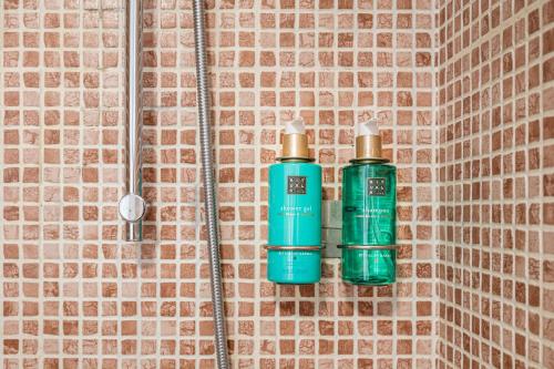two green bottles are hanging on a wall at Ático Pedro Romero in Ronda