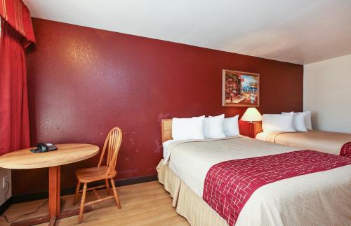 a hotel room with two beds and a table at Red Roof Inn Lompoc in Lompoc