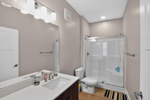 a white bathroom with a sink and a shower at Parkview Greer 2BR Retreat in Greer