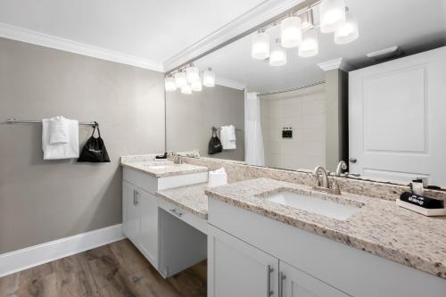 a bathroom with two sinks and a large mirror at Bask Hotel at Big Rock Landing in Morehead City