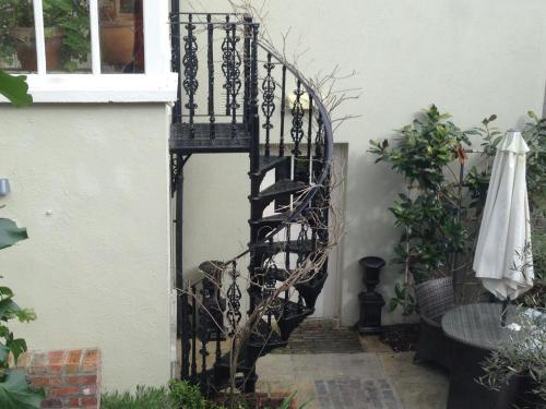 a black spiral staircase in the side of a house at Raheen House Hotel in Clonmel