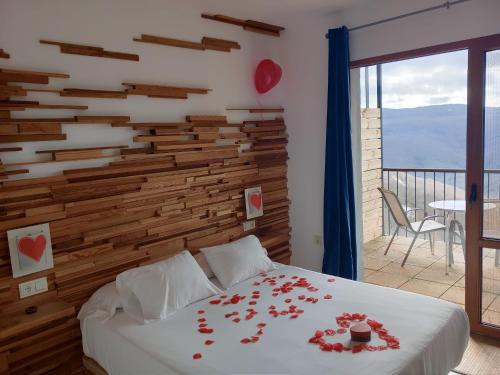 a bedroom with a bed with roses on it at Hotel Rural Porta Coeli - Dehesa Santa Lucía in San Martín del Castañar