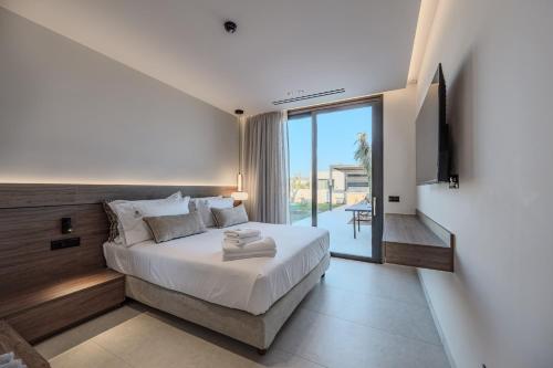 a bedroom with a large bed and a balcony at Nysa Luxury villas 3-4-5-6 in Heraklion