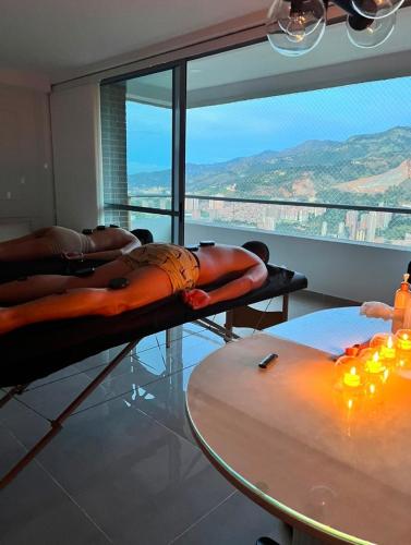 two women laying on beds in a room with a table at Ortega La 33 Hotel y Spa in Medellín