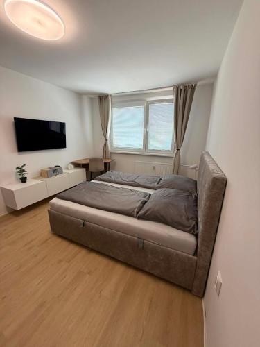 a bedroom with a bed and a flat screen tv at Stylish New Apartment with Parking Place in Bratislava