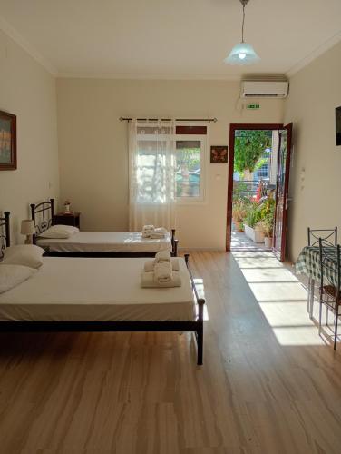 two beds in a room with wooden floors at Lily's Studios in Nikiana