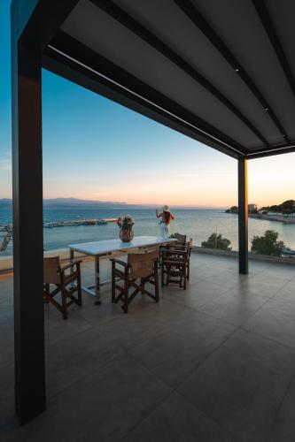 a dining room with a table and a view of the ocean at Filippos Apartments in Amarynthos