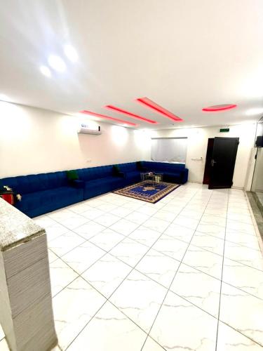 a living room with a blue couch and a white tile floor at شاليهات زارا 2 in Taif