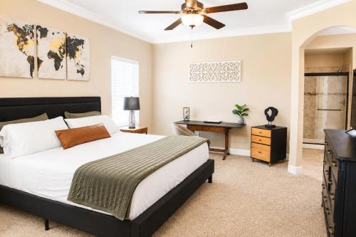 a bedroom with a bed and a desk and a ceiling fan at The Palo Pinto in Alamogordo