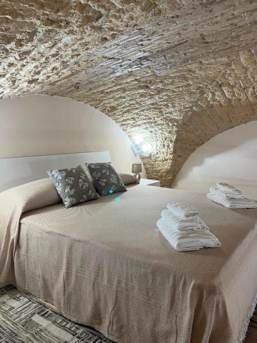 a bedroom with a bed under a stone wall at Imperial House in Poggio Imperiale