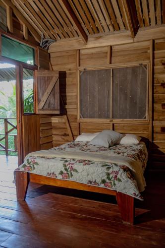a bedroom with a bed in a wooden cabin at Oski Lodge, Rain Forest Rincón de la Vieja in Upala
