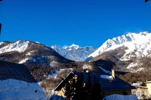 a view of snow covered mountains from a house at Family mountain retreat with breathtaking views in Le Monêtier-les-Bains