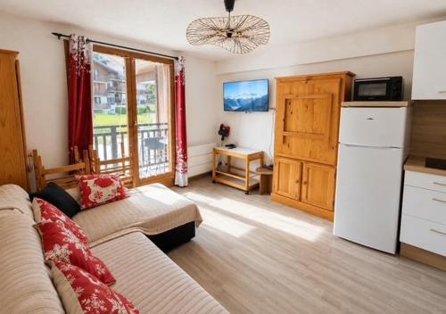 a living room with a couch and a refrigerator at Studio à Praz-sur-Arly in Praz-sur-Arly