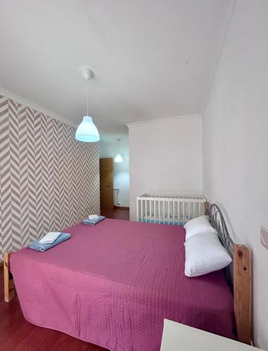 a bedroom with a large bed with a purple blanket at Douro & Sabor Escape in Torre de Moncorvo