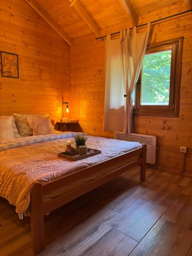 a bedroom with a large bed in a wooden room at Brvnara Dina in Železnička Stanica Dolovo