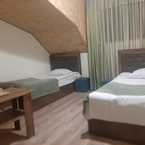 a hotel room with two beds and a table at Hotel Noy in Goris