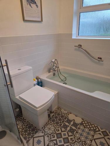 ein Badezimmer mit Toilette und Badewanne in der Unterkunft Firefly Studio in Holt