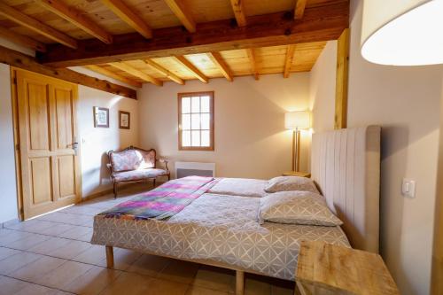 a bedroom with a bed and a chair at Location Le Penan in Léon