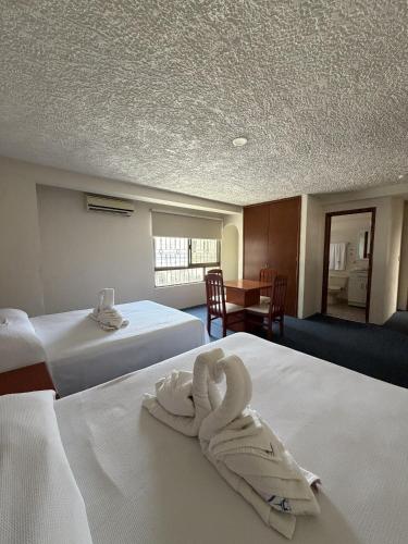 a hotel room with two beds with towels on them at Hotel NV in Guadalajara