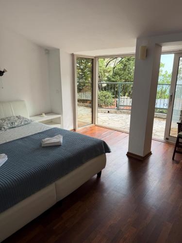 a bedroom with a bed and a sliding glass door at Vila Srna in Petrovac na Moru