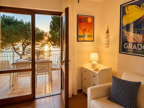 a living room with a door open to a balcony at BeachfrontGrado Seaview Apartment Costa Azzurra in Grado