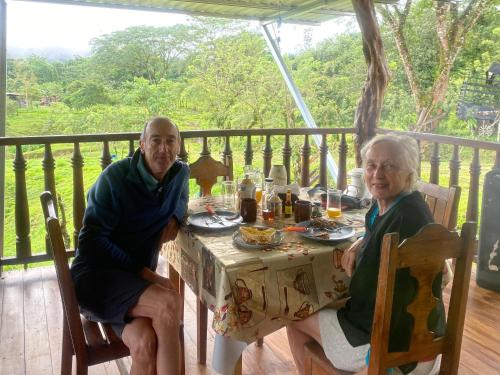 two older men sitting at a table with food at Cabañas venado 2 in Venado