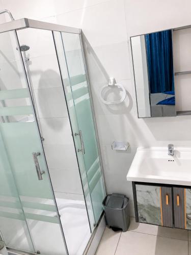 a bathroom with a glass shower and a sink at Mags GuestHouse in Praia