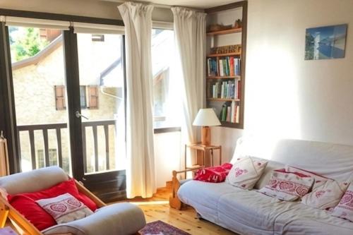 a living room with a couch and a large window at Family mountain retreat with breathtaking views in Le Monêtier-les-Bains