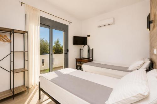 a bedroom with two beds and a window at Villa Livis 1 in Kiotari
