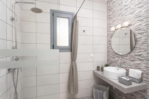 a white bathroom with a sink and a mirror at Villa Livis 1 in Kiotari