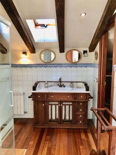 a bathroom with a sink and two mirrors at Caserio Arrigorri in Murguía