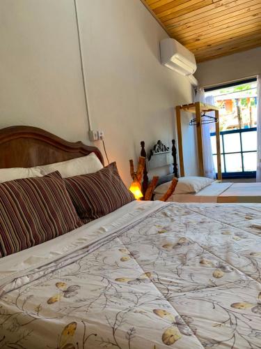 a bedroom with a large bed with a large bedspread at Pousada Bosque das Borboletas in Sabará
