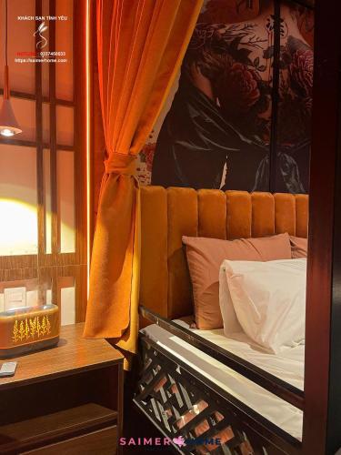 a bedroom with a bed with an orange curtain at Saimer Home in Tân Thành (1)