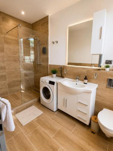 a bathroom with a washing machine and a sink at Kurvilla Hotel & Apartment in Landstuhl