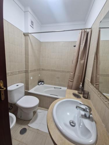 ein Badezimmer mit Waschbecken, Toilette und Badewanne in der Unterkunft CasaSoldoré in Sesimbra