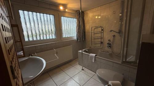 a bathroom with a sink and a tub and a toilet at Ferienwohnung mit eigenem Pool und finnischer Sauna in Witten in Witten