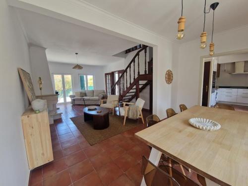 ein Wohnzimmer mit einem Tisch und ein Esszimmer in der Unterkunft CasaSoldoré in Sesimbra