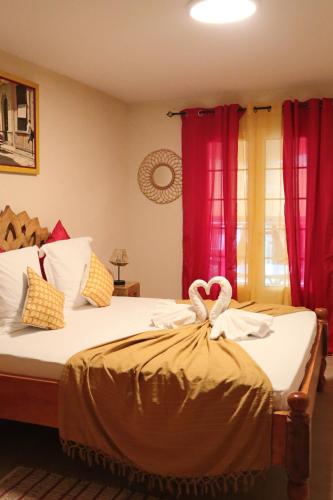 a bedroom with a bed with two swans on it at Résidence Simona Premium in Deshaies
