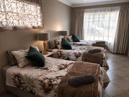 a bedroom with two beds and a couch at Galago Rest in Leeupoort