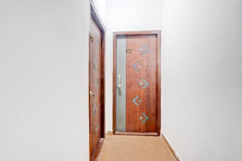 an open wooden door with a mirror in a hallway at Hotel O Rainbow in Warangal
