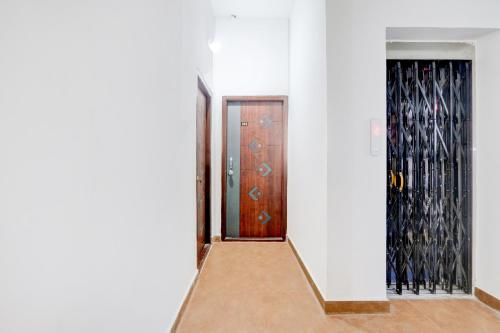 a hallway with a wooden door and wine racks at Hotel O Rainbow in Warangal